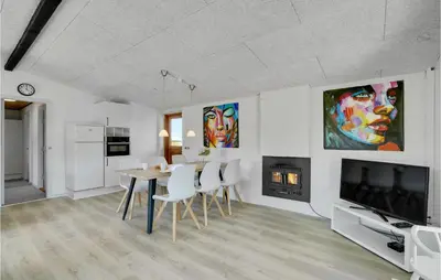 a dining room with a table and a fireplace at 3 Bedroom Lovely Home In Spøttrup in Spottrup