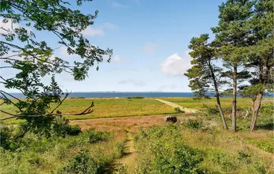 a dirt road in the middle of a field with trees at Cozy Home In Vesløs With House Sea View in Øsløs