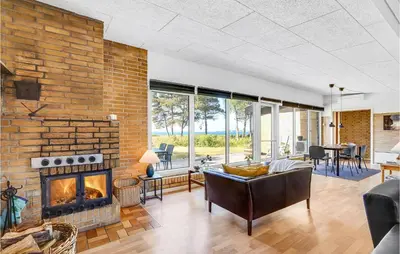 a living room with a brick wall and a fireplace at Cozy Home In Vesløs With House Sea View in Øsløs