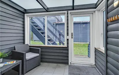 a screened in porch with a chair and windows at Stunning Home In Hanstholm in Hanstholm