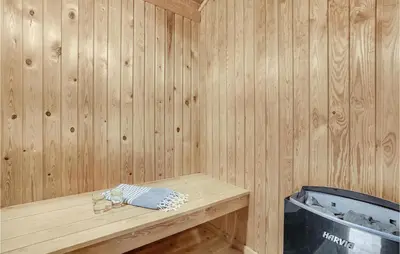 a wooden sauna with a bench and a trash can at Cozy Home In Harboøre With Sauna in Harboør