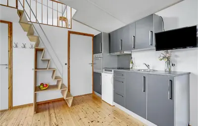 a kitchen with gray cabinets and a staircase at Gorgeous Home In Vestervig With Kitchen in Vestervig