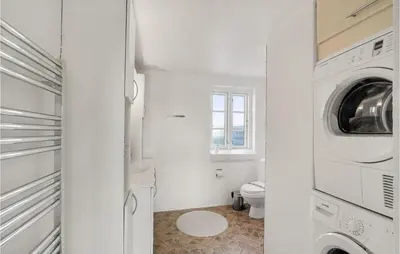 a white bathroom with a toilet and a washer and dryer at Pet Friendly Home In Vils With Sauna in Vils