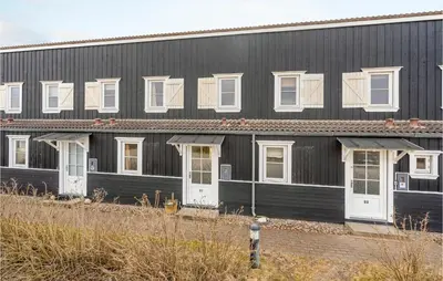 a black building with white doors and windows at Agger Havn Feriecenter in Vestervig