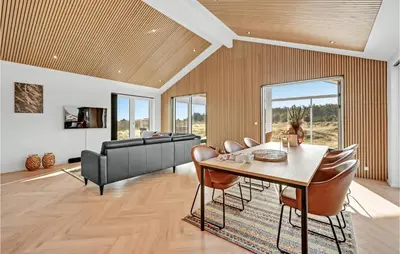 a dining room with a table and chairs and a couch at Awesome Home In Harboøre With Kitchen in Harboør