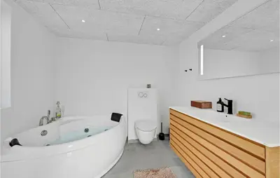a white bathroom with a tub and a toilet at Awesome Home In Harboøre With Kitchen in Harboør