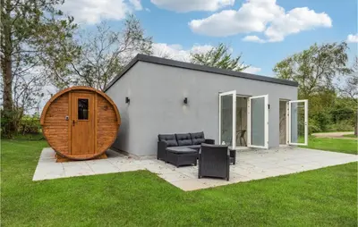 a small house with a large wooden door at Awesome Home In Nibe With Kitchen in Nibe