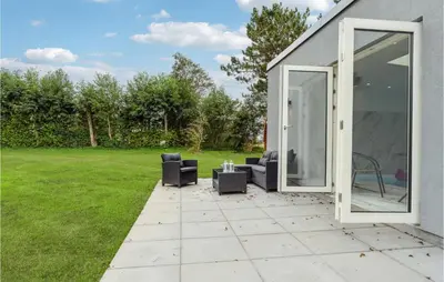 a patio with two chairs and an open door at Awesome Home In Nibe With Kitchen in Nibe