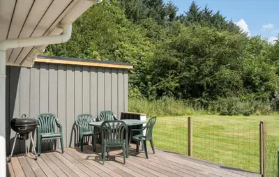 a deck with a table and chairs and a grill at Lovely Home In Bedsted Thy With Sauna in Bedsted Thy