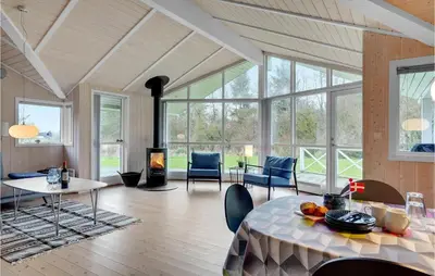 a living room with a table and a fireplace at Lovely Home In Bedsted Thy With Sauna in Bedsted Thy