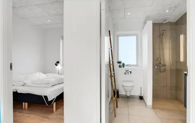 a bedroom with a shower and a bed in a room at Nice Home In Blokhus With Sauna in Blokhus