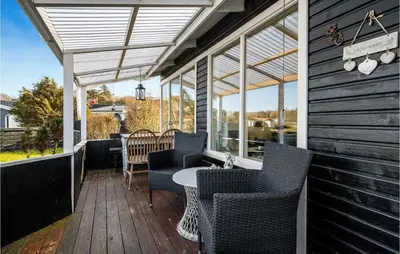 a patio with chairs and a table on a deck at 1 Bedroom Lovely Home In Løgstør in Løgstør