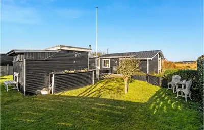 a backyard with a house and a yard with a tree at 1 Bedroom Lovely Home In Løgstør in Løgstør
