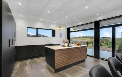 a kitchen with black cabinets and a large window at Gorgeous Home In Thisted With Wifi in Thisted