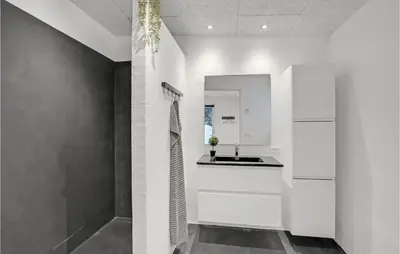 a white bathroom with a sink and a mirror at Beautiful Home In Vestervig With Wifi in Vestervig