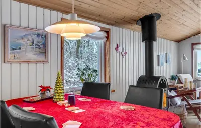 a dining room with a red table with a christmas tree on it at 2 Bedroom Awesome Home In Thyholm in Thyholm