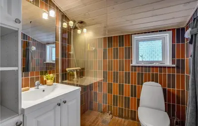 a bathroom with a sink and a toilet and a window at 2 Bedroom Awesome Home In Thyholm in Thyholm