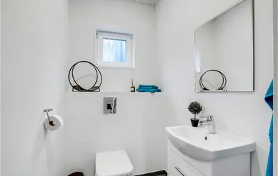 a white bathroom with a sink and a mirror at Gorgeous Home In Thyholm With Wifi in Thyholm