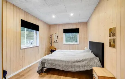 a bedroom with a bed and two windows at Gorgeous Home In Thyholm With Wifi in Thyholm