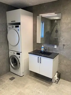 a bathroom with a washing machine and a sink at Hytten in Lemvig