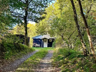 a dirt road in front of a blue barn at 4 person holiday home in Aars-By Traum in Års