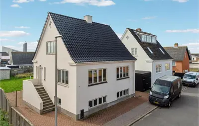 a white house with a van parked in front of it at Lovely Home In Thyborøn With Kitchen in Thyborøn