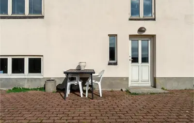 a table and two chairs in front of a building at Lovely Home In Thyborøn With Kitchen in Thyborøn