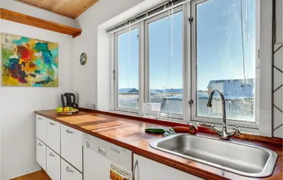 a kitchen with a sink and two windows at Lovely Home In Thyborøn With Kitchen in Thyborøn