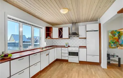 a kitchen with white cabinets and a wooden ceiling at Lovely Home In Thyborøn With Kitchen in Thyborøn