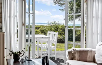 an open door to a patio with a table and chairs at 3 Bedroom Cozy Home In Hurup Thy in Sønder Ydby