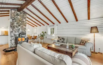 a living room with a couch and a table at 3 Bedroom Cozy Home In Hurup Thy in Sønder Ydby