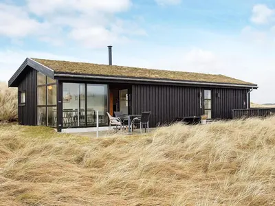 a small black house with a table and chairs at 6 person holiday home in Pandrup-By Traum in Pandrup