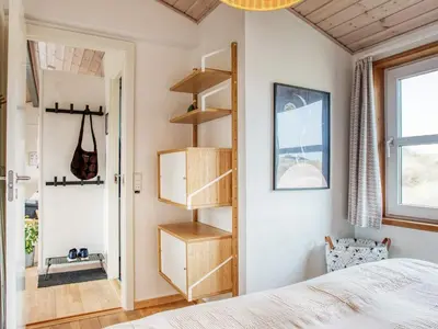a bedroom with a bed and wooden shelves at 6 person holiday home in Pandrup-By Traum in Pandrup