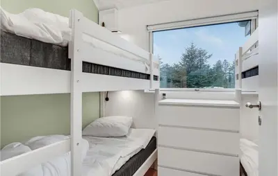 a bedroom with two bunk beds and a window at Gorgeous Home In Blokhus With Jacuzzi in Blokhus