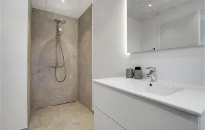 a white bathroom with a shower and a sink at Gorgeous Home In Blokhus With Jacuzzi in Blokhus