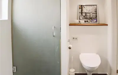 a bathroom with a white toilet and a door at Cozy Home In Lemvig With Wifi in Lemvig