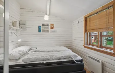 a bed in a room with white walls and a window at Holiday Home Jelsevej Ix in Højslev