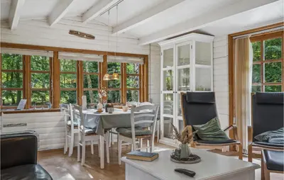 a dining room with a table and chairs and windows at Holiday Home Jelsevej Ix in Højslev