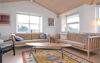a living room with couches and a table at Holiday Home Egebækvej in Blokhus