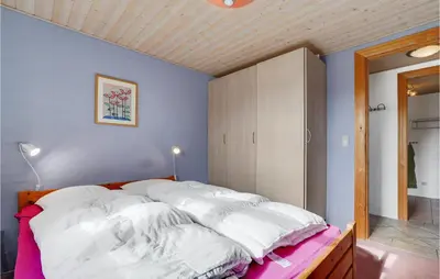 a bedroom with a large bed with white sheets at Holiday Home Strandlyst Vinderup Iv in Vinderup