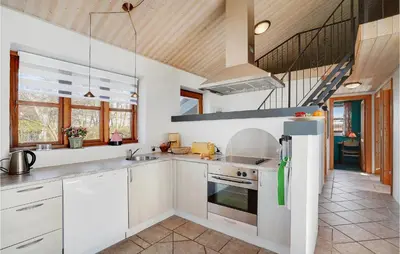 a kitchen with white cabinets and a staircase at Holiday Home Strandlyst Vinderup Iv in Vinderup
