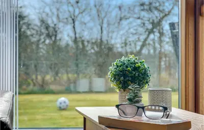 a table with glasses and a vase with a plant at Holiday Home Strandlyst Vinderup Iv in Vinderup