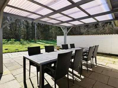 a wooden table and chairs under a pergola at 6 person holiday home in Vesløs-By Traum in Øsløs