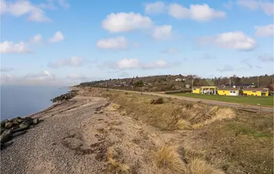 a rocky shoreline with houses and the ocean at 3 Bedroom Amazing Home In Spøttrup in Spottrup