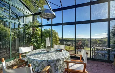 a conservatory with a table and chairs and a large window at 5 Bedroom Awesome Home In Erslev in Erslev