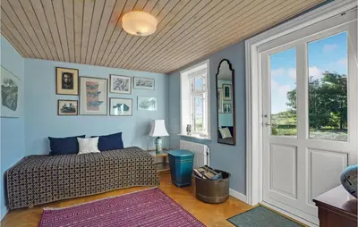 a bedroom with a bed and a window and a door at 5 Bedroom Awesome Home In Erslev in Erslev