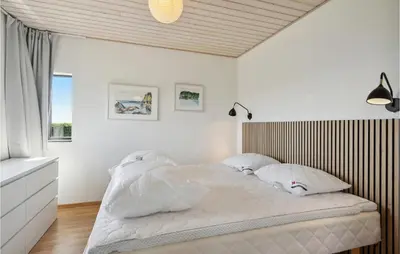 a bedroom with a bed with white sheets and pillows at Nice Home In Øster Assels With Wifi in Øster Assels