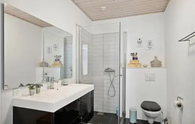 a white bathroom with a sink and a toilet at Nice Home In Øster Assels With Wifi in Øster Assels