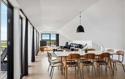 a dining room and living room with a table and chairs at Nice Home In Øster Assels With Wifi in Øster Assels
