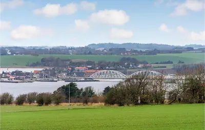 a bridge over a body of water with a green field at Nice Home In Erslev With Wifi in Erslev